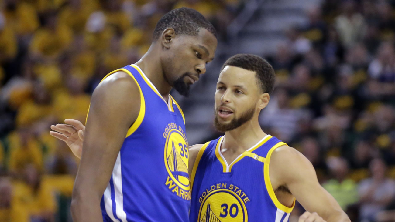 Golden State Warriors' Stephen Curry and Kevin Durant talk in the first half during Game 3 of an NBA playoff series in Salt Lake City, Utah.