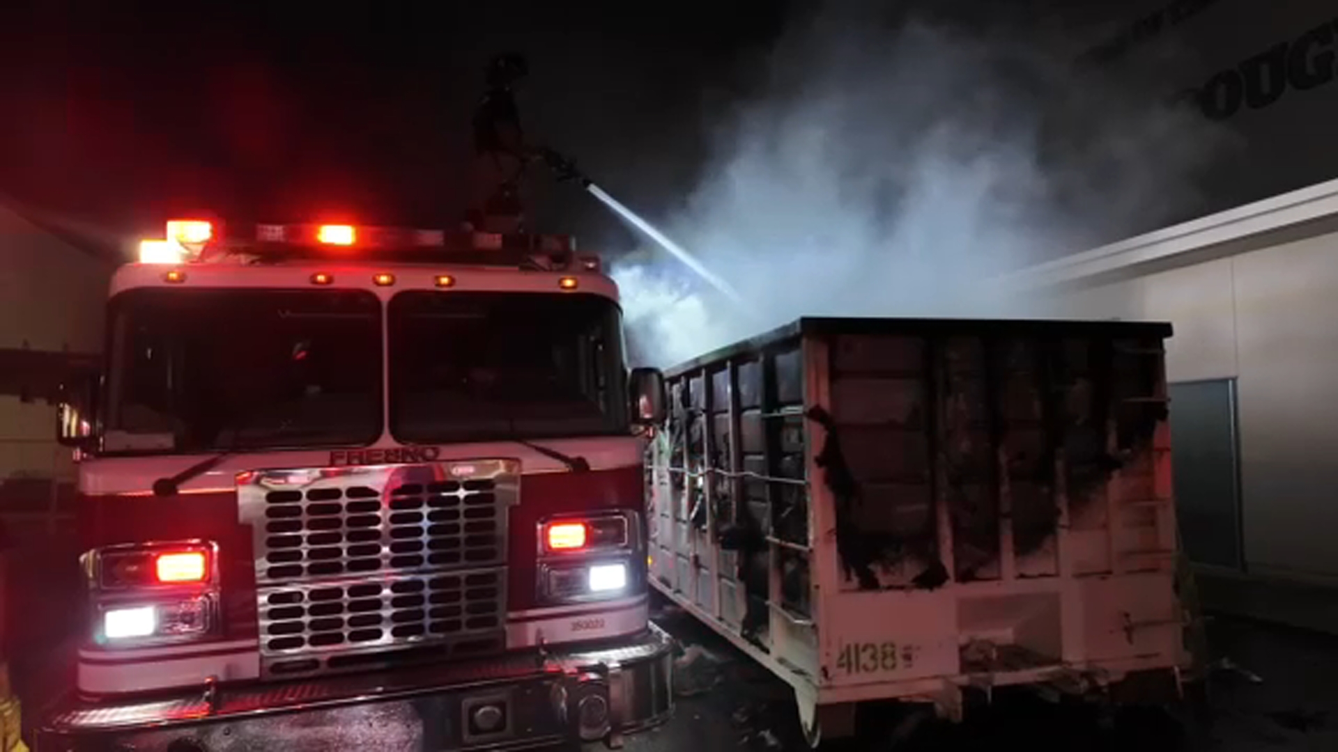 Firefighters protecting Roosevelt High School after dumpster fire