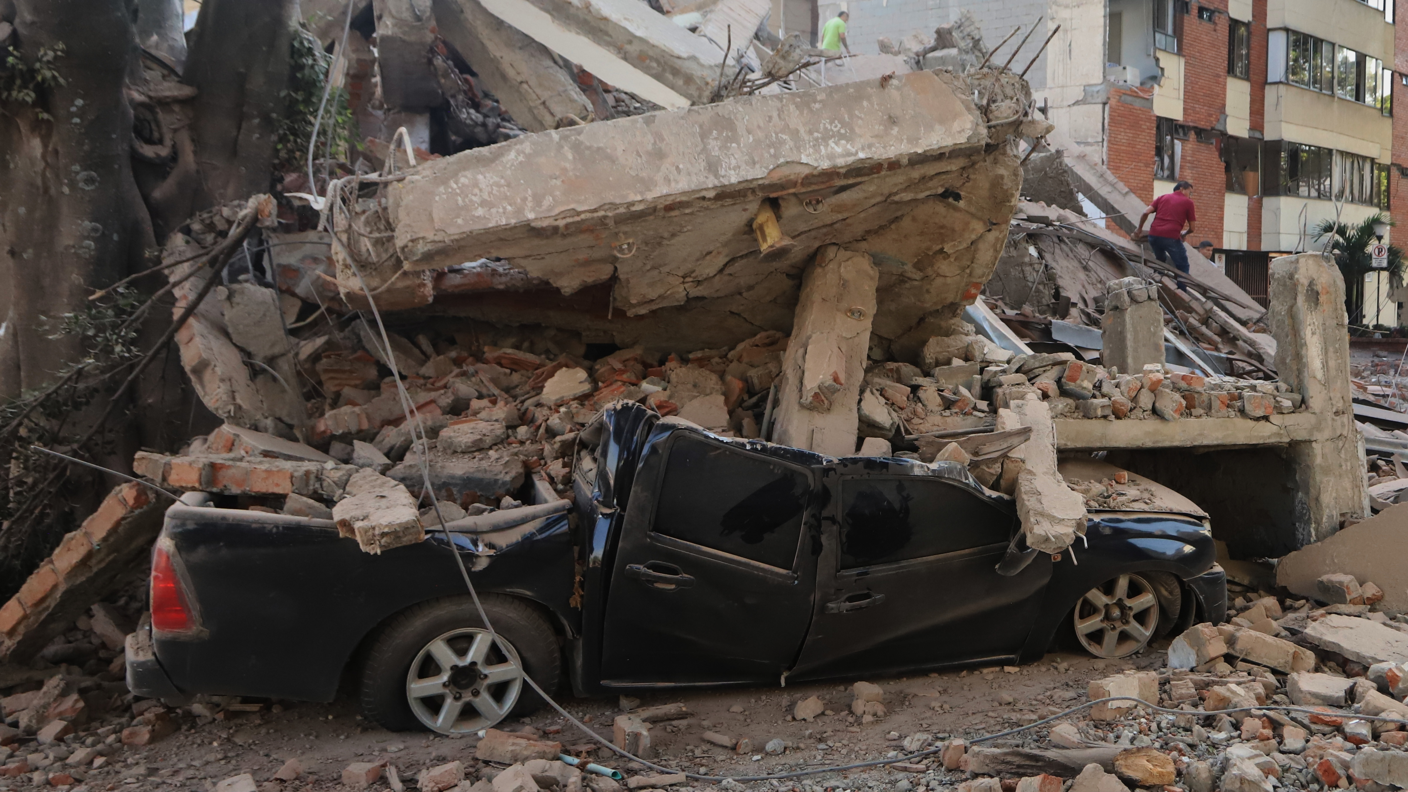 A vehicle is crushed by debris after an earthquake struck Cali, Colombia, Monday, Aug. 10, 2026.