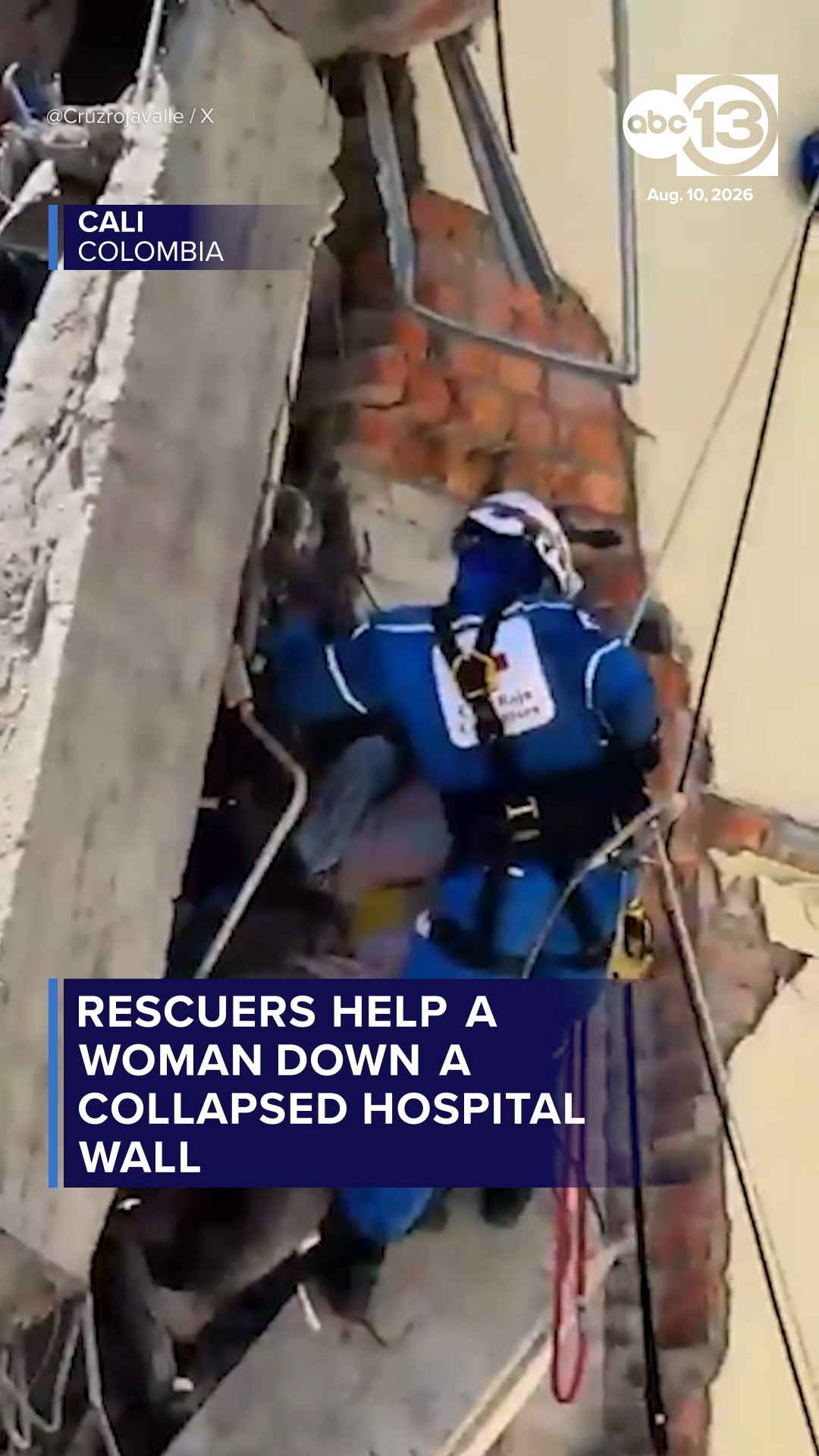 Rescuers help a woman down a collapsed hospital wall