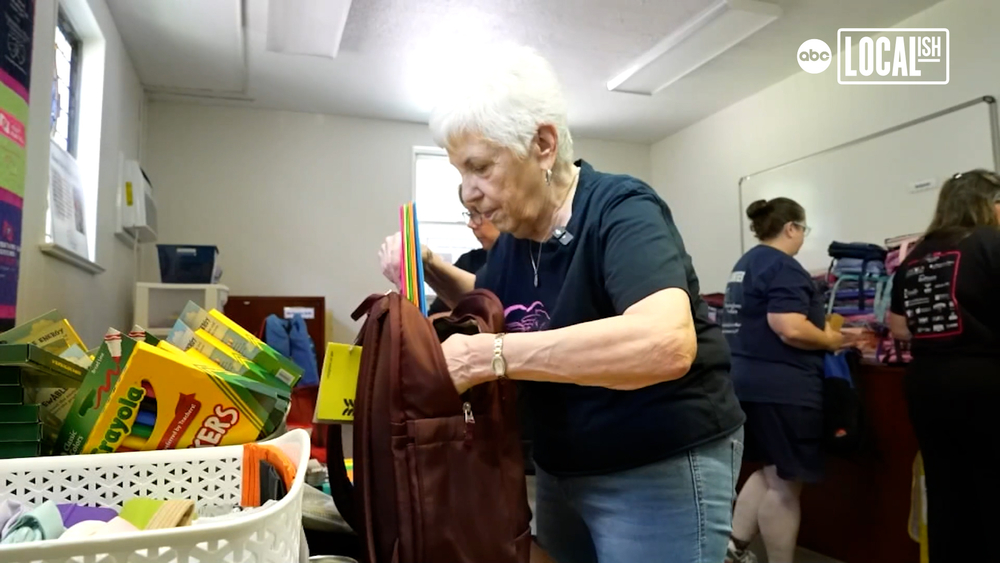 Volunteers pack book bags for families dealing with cancer