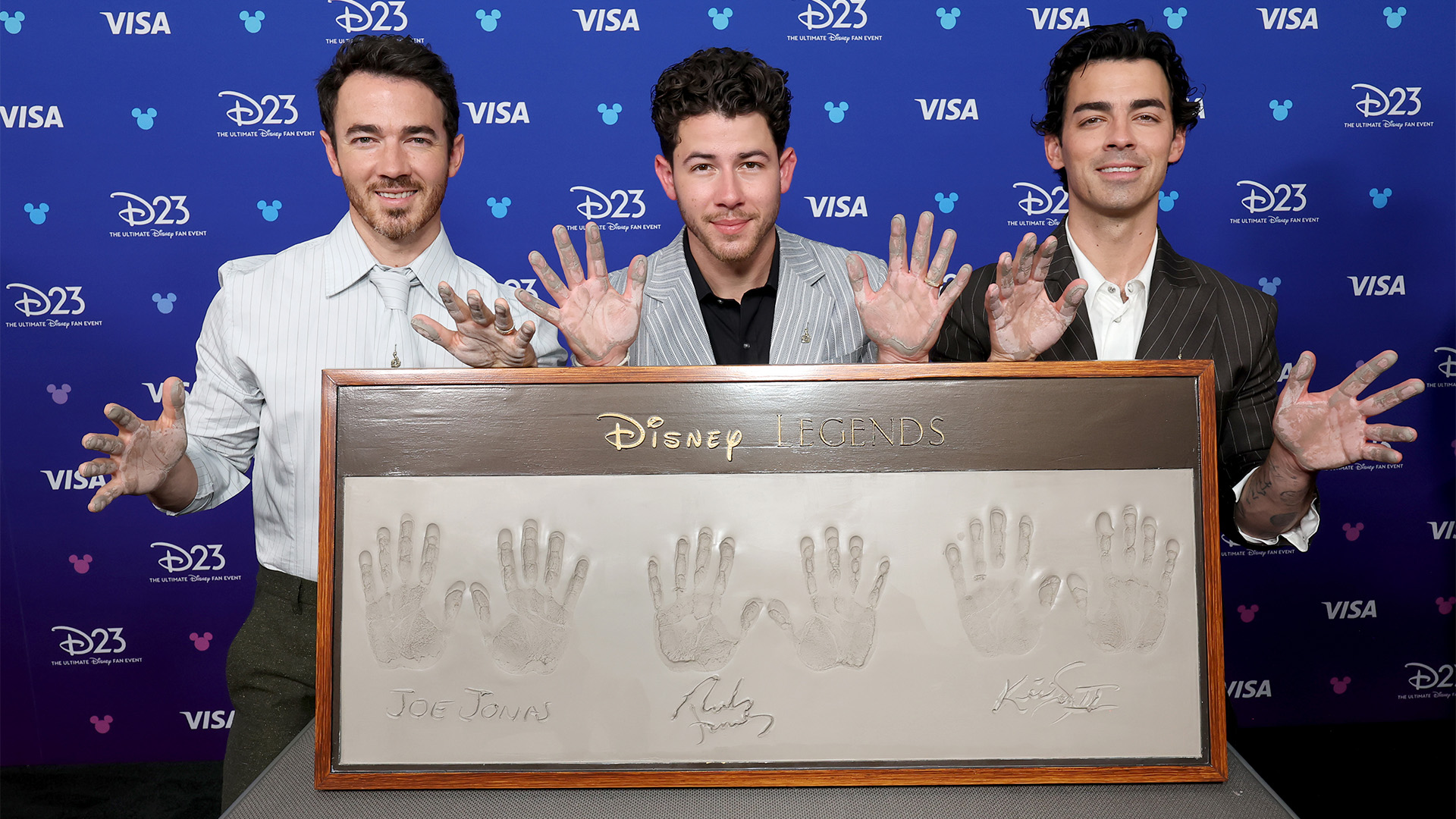 Kevin Jonas, Nick Jonas and Joe Jonas get their handprints at D23 on August 16, 2026 in Anaheim, California.
