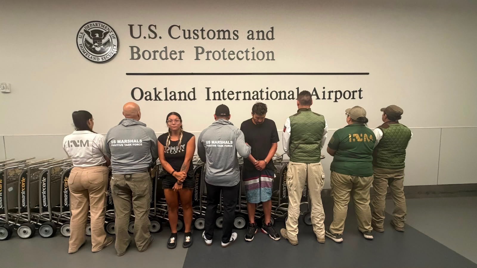 Suspects Misty Gomez (left forward), Antonio Garcia and members of the U.S. Marshals team that apprehended them in Mexico.