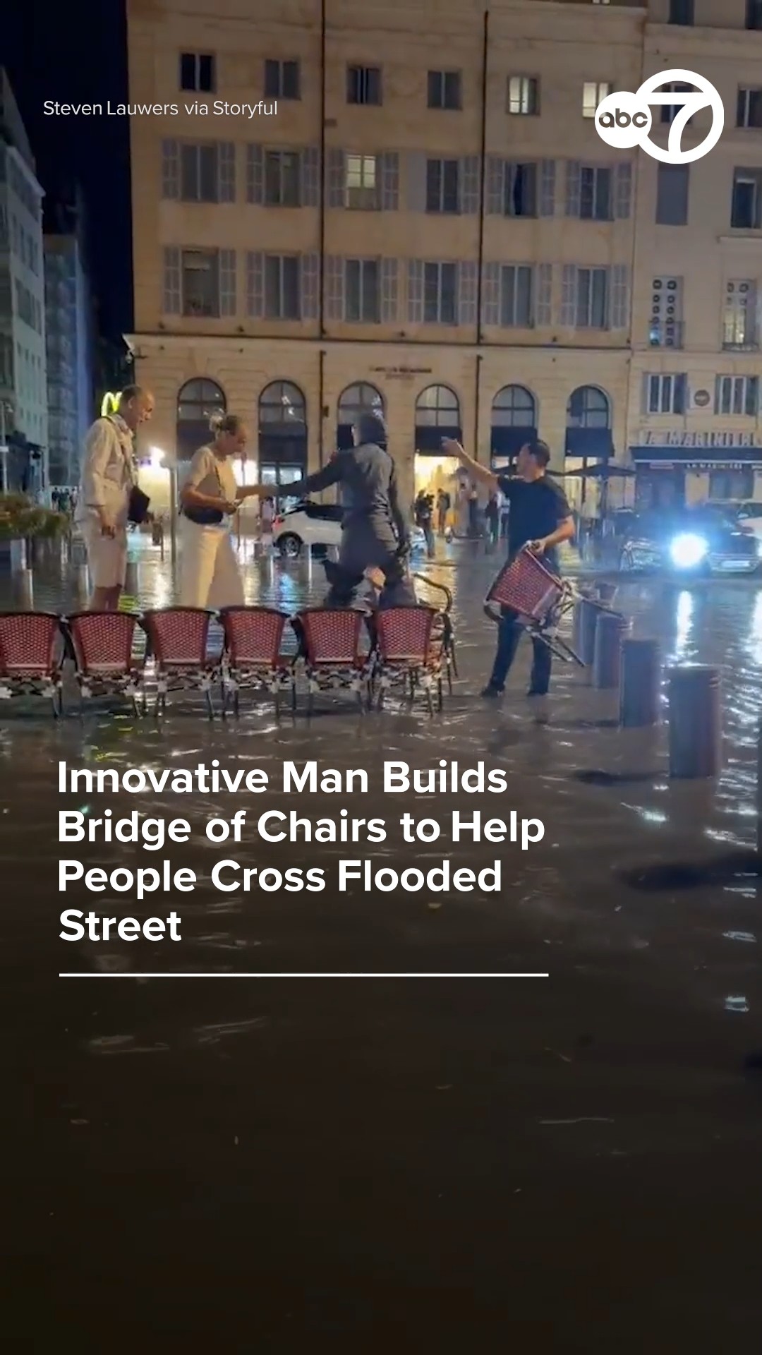 Innovative man builds bridge of chairs to help cross flooded street 
