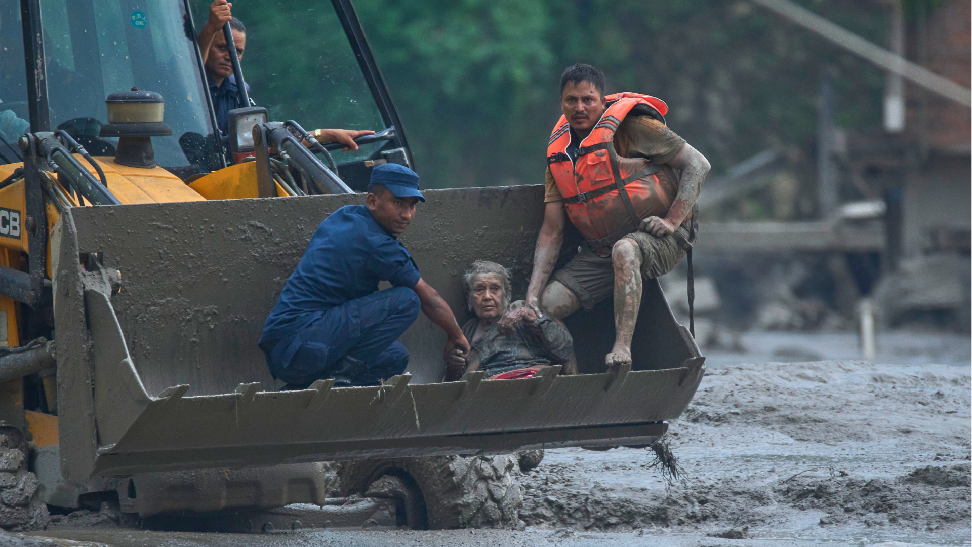 Rescuers use an earthmover to carry a victim of flash flooding to safety along the Trishuli River in Nepal's Nuwakot district, Wednesday, Aug. 26, 2026.