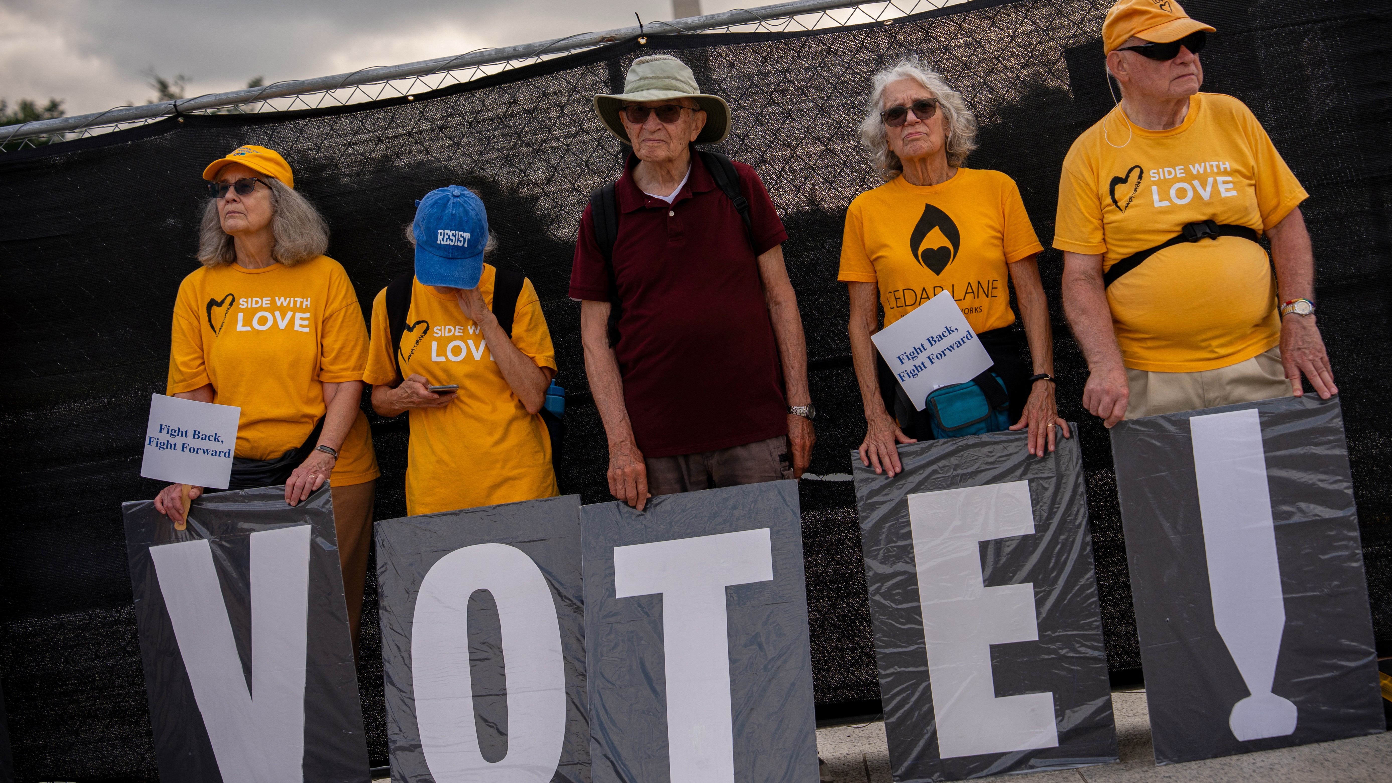 Demonstrators hold signs in front of fencing surrounding the Lincoln Memorial Reflecting Pool, during the March on Washington, Friday, Aug. 28, 2026, in Washington.
