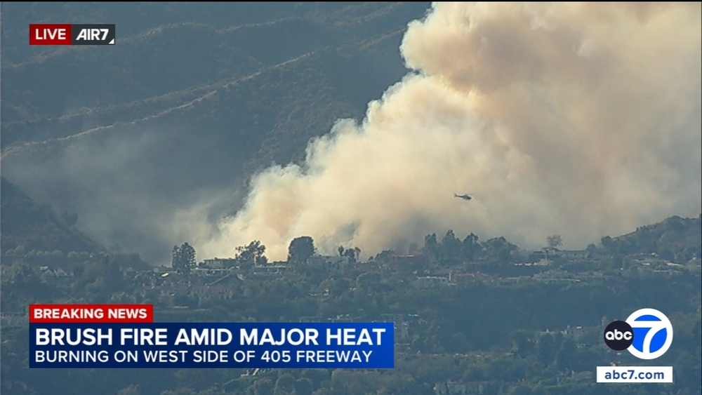 Firefighters battle brush fire along 405 Freeway in Sepulveda Pass