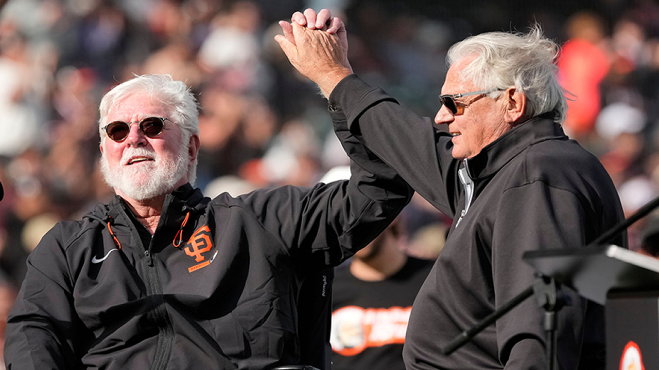 Mike Krukow, left, and Duane Kuiper, right, raise their hands for the crowd during the San Francisco Giants ceremony to celebrate Mike Krukow, on Sunday, Sept. 27, 2026.
