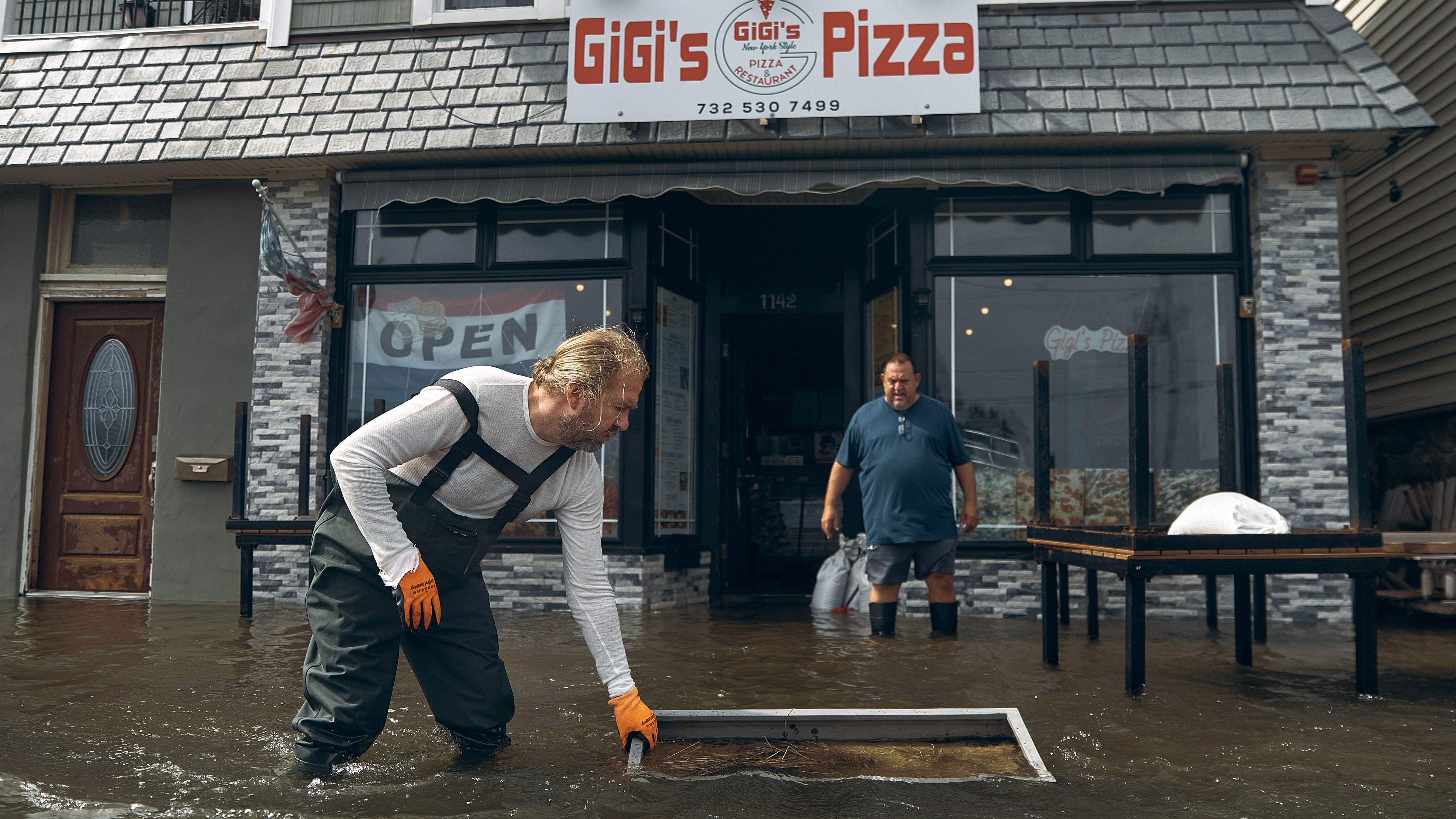 People clean a flooded pizza restaurant during a nor'easter storm on Sunday, Sept. 27, 2026, in Sea Bright, N.J. 