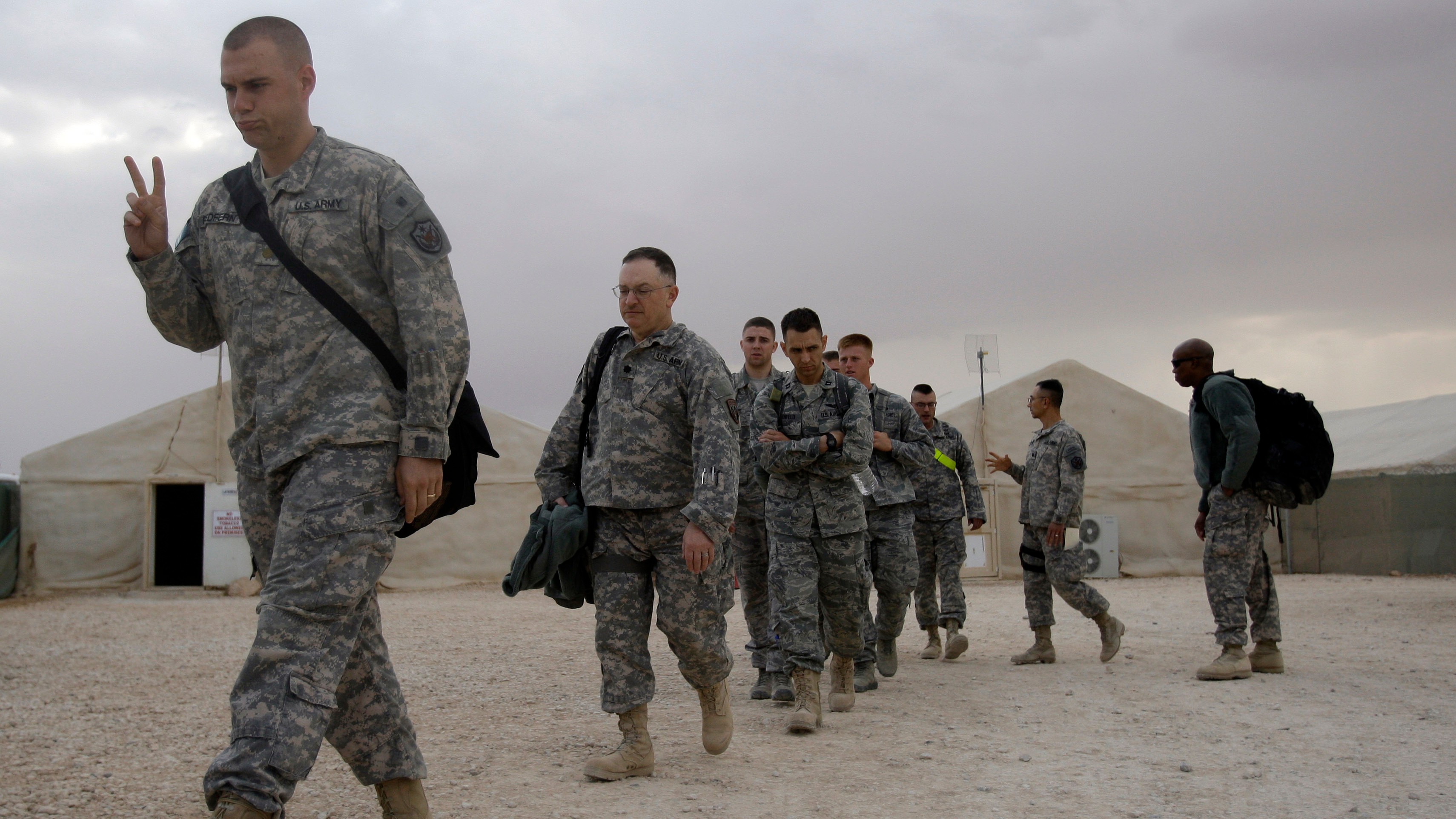 A U.S. army soldier flashes a V for victory sign as he begins his journey home, at the al-Asad Air Base west of Baghdad, Iraq, Nov. 1 , 2011.