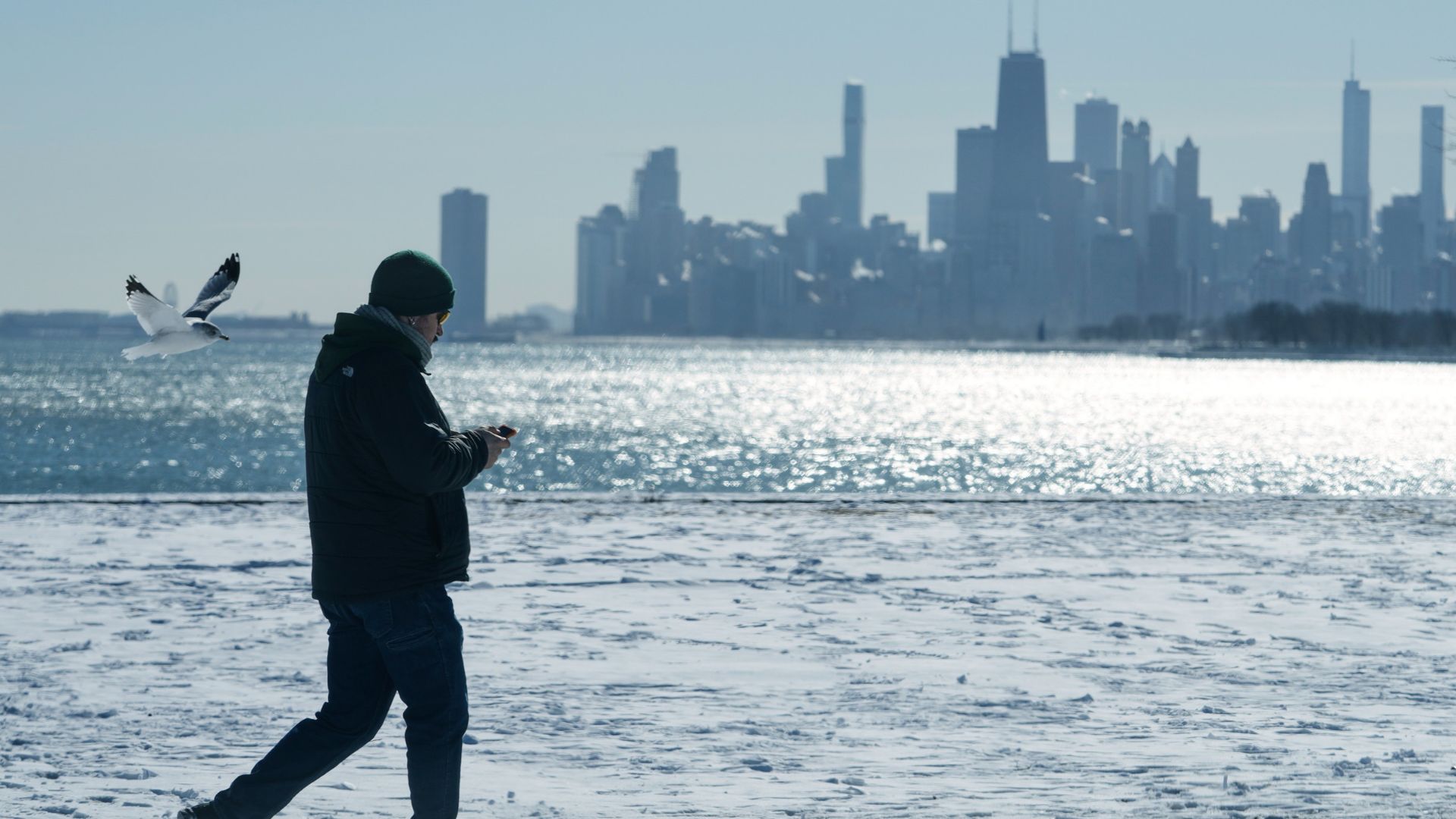 A person walks near the snow-covered sand at Lake Michigan in Chicago, Jan. 28, 2026.