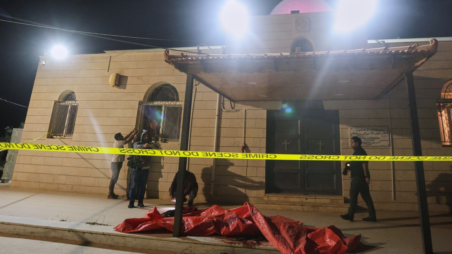 Outside a Greek Orthodox church cordoned off with crime scene tape hours after gunmen opened fire during a funeral in Hamoud village, in Jordan's Karak governorate.
