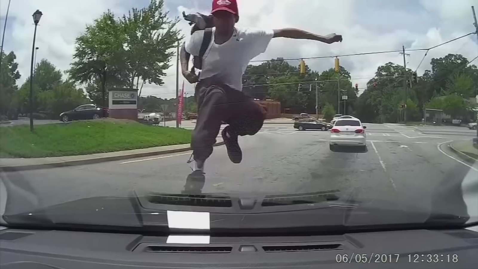 Video shows man randomly jump on woman's car, kick in windshield ABC7