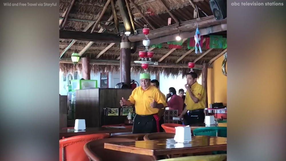 Server balances six margaritas on his head