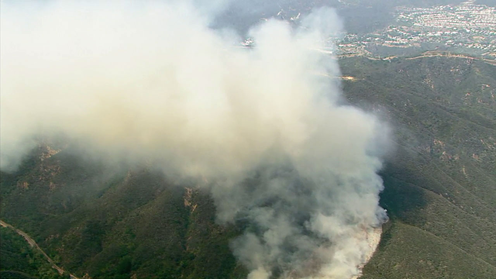 Archival aerial photograph of smoke rising from a Malibu hillside brush fire in 2017, not the current Bryson Fire