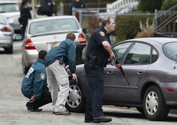 Police surround a home while searching for a suspect in the Boston Marathon bombings in Watertown, Mass., Friday, April 19, 2013. The two suspects in the Boston Marathon bombing killed an MIT police officer and hurled explosives at police in a car chase and gun battle overnight that left one of them dead and his brother on the loose, authorities said Friday. (AP Photo/Charles Krupa)