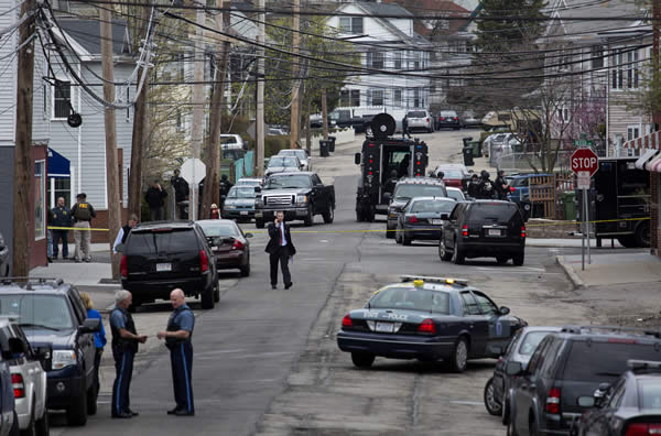 Police presence grows in the neighborhoods of Watertown, Mass., Friday, April 19, 2013, as a massive search involving hundreds of heavily armed law enforcement officials continues for one of two suspects in the Boston Marathon bombing. A second suspect died in the early morning hours in a car chase and gun battle overnight that left one of them dead and his brother on the loose, authorities said Friday.