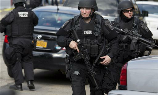 Heavily armed police continue to patrol the neighborhoods of Watertown, Mass. Friday, April 19, 2013, as they continue a massive search for one of two suspects in the Boston Marathon bombing.