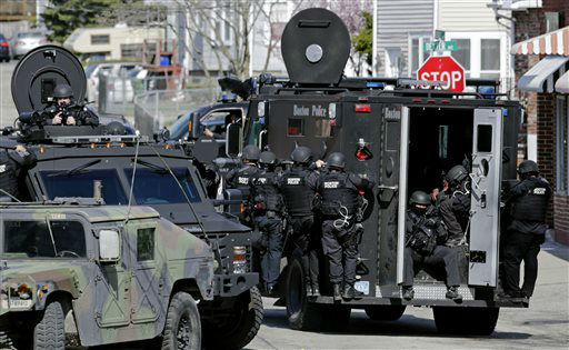 Tactical teams drive through a neighborhood while searching for a suspect in the Boston Marathon bombings in Watertown, Mass., Friday, April 19, 2013.