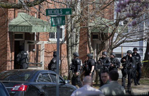 Heavily armed police enter a building in Watertown, Mass. Friday, April 19, 2013, as law enforcement officials continue a massive search for one of two suspects in the Boston Marathon bombing.