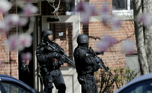 Tactical teams exit an apartment building while searching for a suspect in the Boston Marathon bombings in Watertown, Mass., Friday, April 19, 2013.