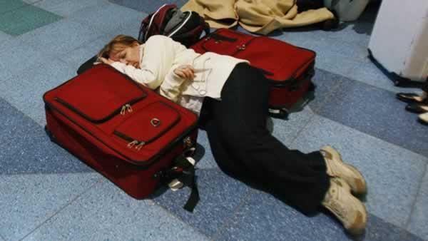 Travelers rest on the floor stranded at the Haneda international airport in Tokyo after a massive earthquake Friday, March 11, 2011. The ferocious tsunami spawned by one of the largest earthquakes ever recorded slammed Japan's eastern coasts. (AP Photo/Wally Santana)