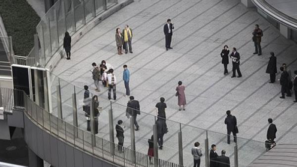 Office workers in Tokyo's Shiodome district near Tokyo Bay stay on the pedestrian deck Friday, March 11, 2011, shortly after a 7.9-magnitude earthquake has struck off Japan's northeastern coast. (AP Photo/Koji Sasahara)