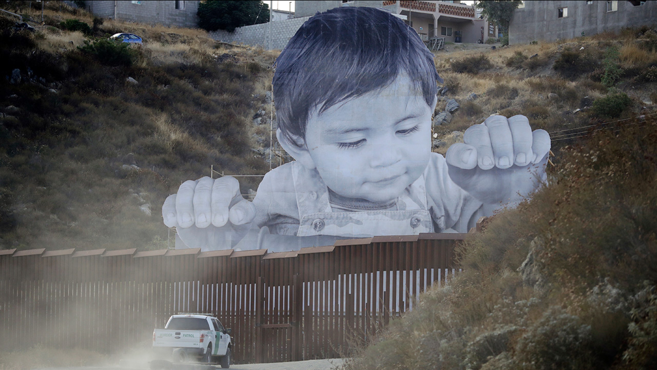 A Border Patrol vehicle drives in front of a mural in Tecate, Mexico, just beyond a border structure Friday, Sept. 8, 2017, in Tecate, Calif.