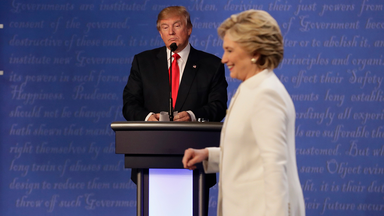 Republican presidential nominee Donald Trump waits behind his podium as Democratic presidential nominee Hillary Clinton makes her way off the stage.