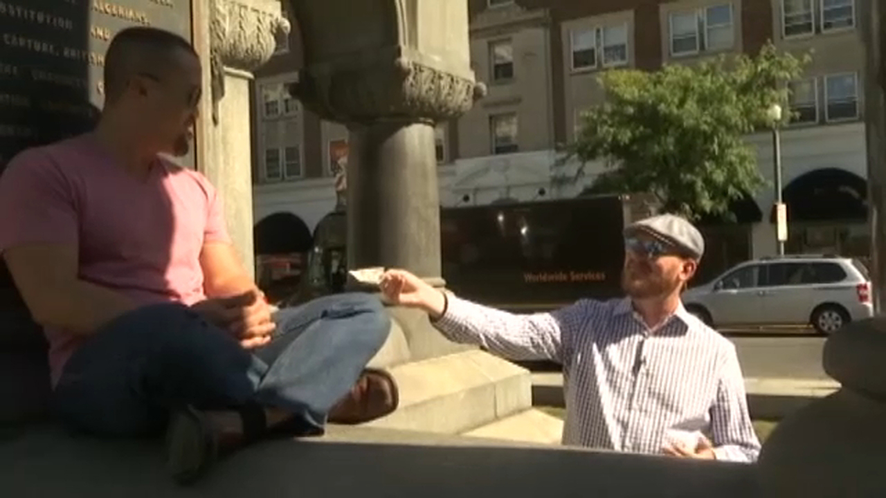 Man hands out cash to strangers