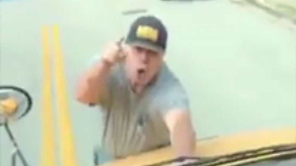 Man climbs onto moving bus