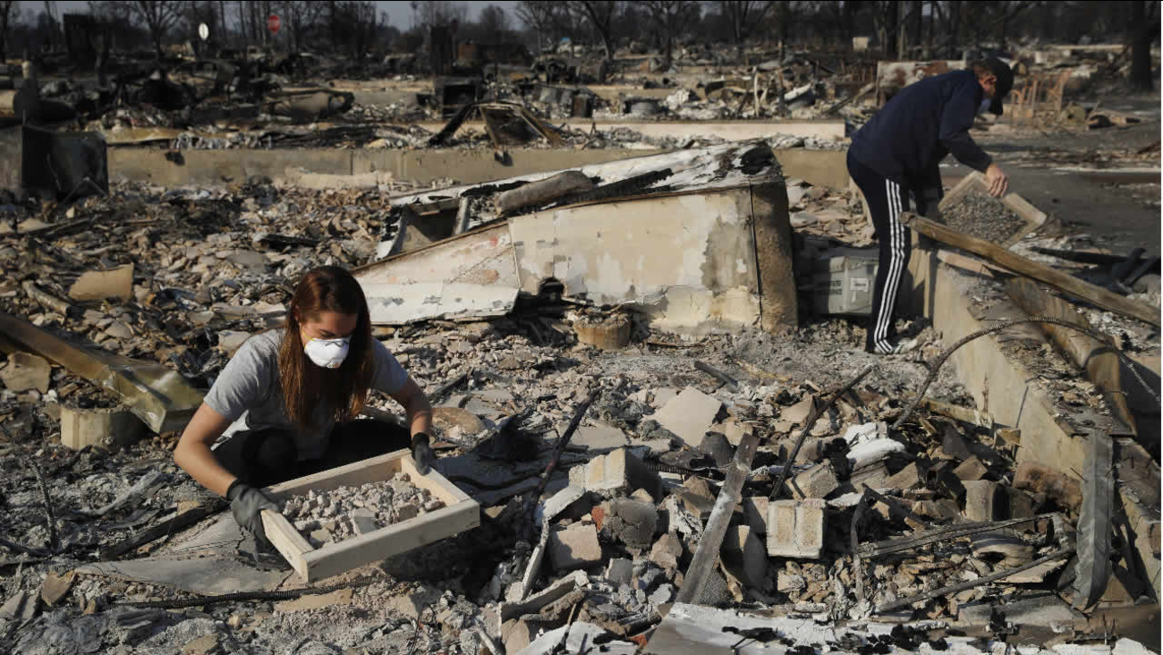 Residents search through rubble of their home destroyed by a wildfire in the Coffey Park neighborhood Sunday, Oct. 15, 2017, in Santa Rosa, Calif.