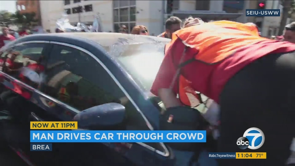 Driver moves car through crowd of protesters in Brea intersection