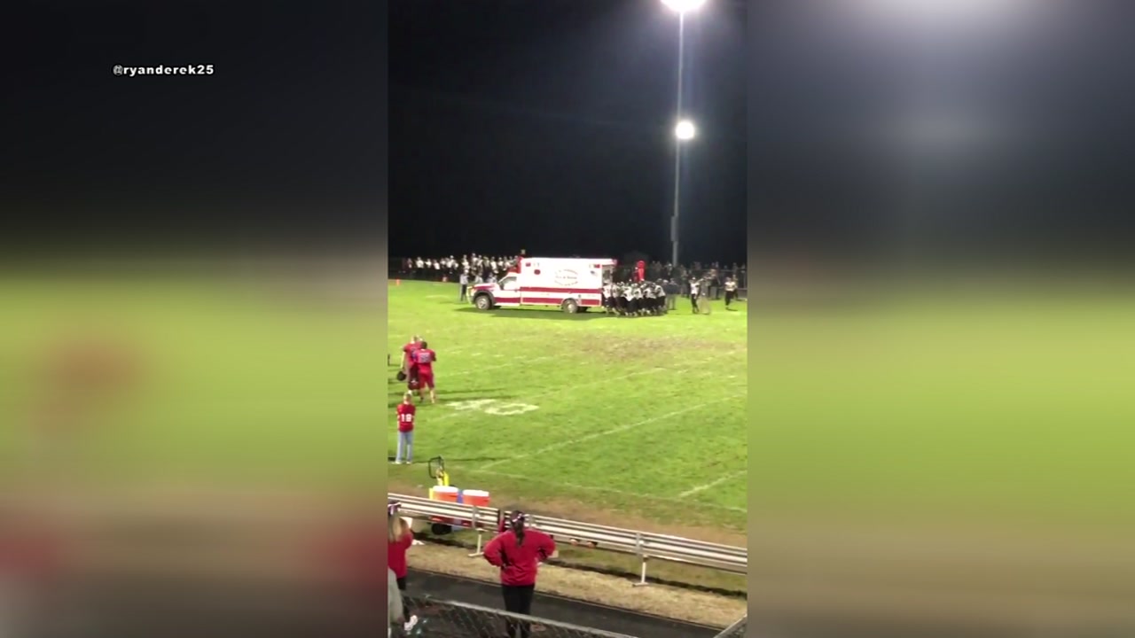 High school football players help push stuck ambulance