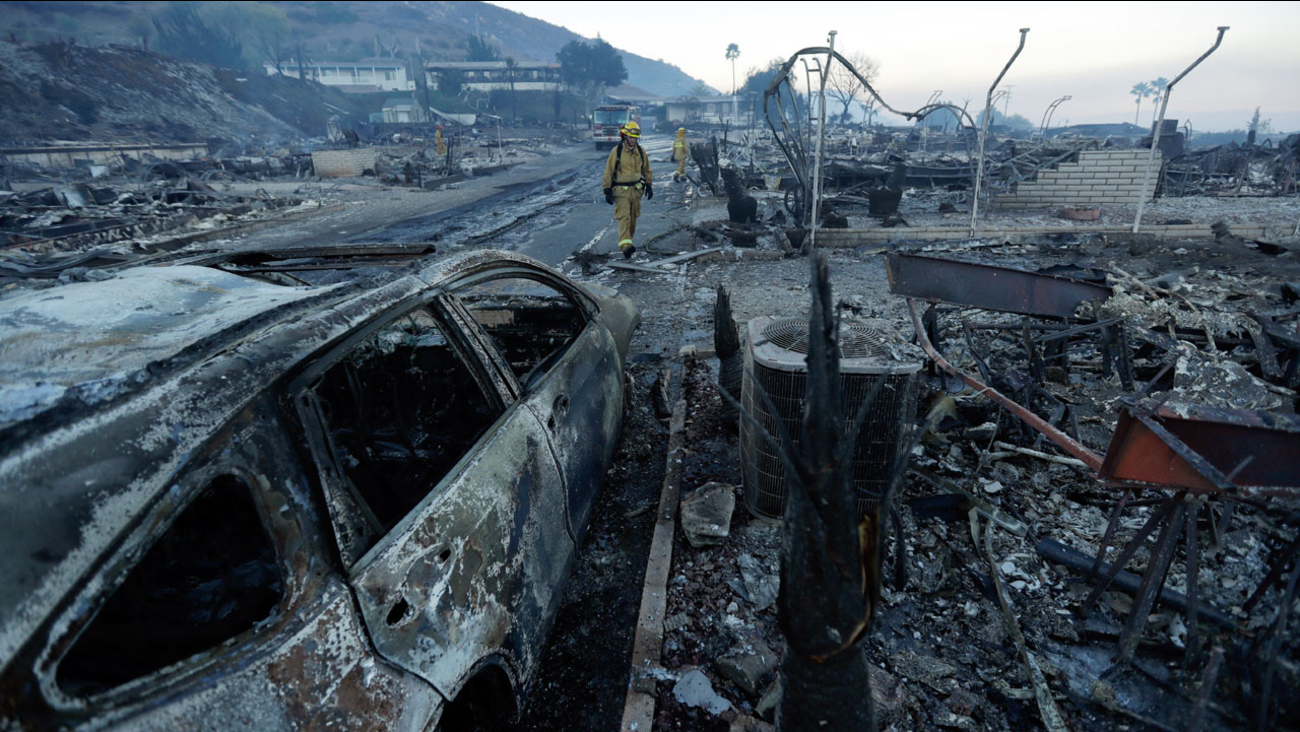 Fire crews search for hot spots among destroyed homes in the Rancho Monserate Country Club community Friday, Dec. 8, 2017, in Fallbrook, Calif.