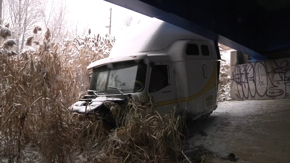 Tractor-trailer overturns causing front cab to fall off overpass on Blue Route