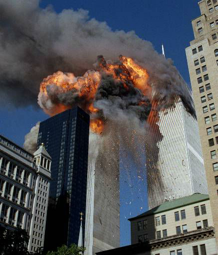 Smoke, flames and debris erupts from one of the World Trade Center towers as a plane strikes it Tuesday, September 11, 2001.