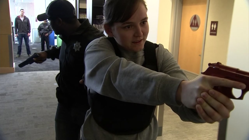 Officers with guns drawn, scramble through a community college library shouting "Shots Fired! Shots Fired!"  It's a realistic training scenario that mimics real-world events likely the deadly school shooting at Columbine High School nearly twenty years ago.