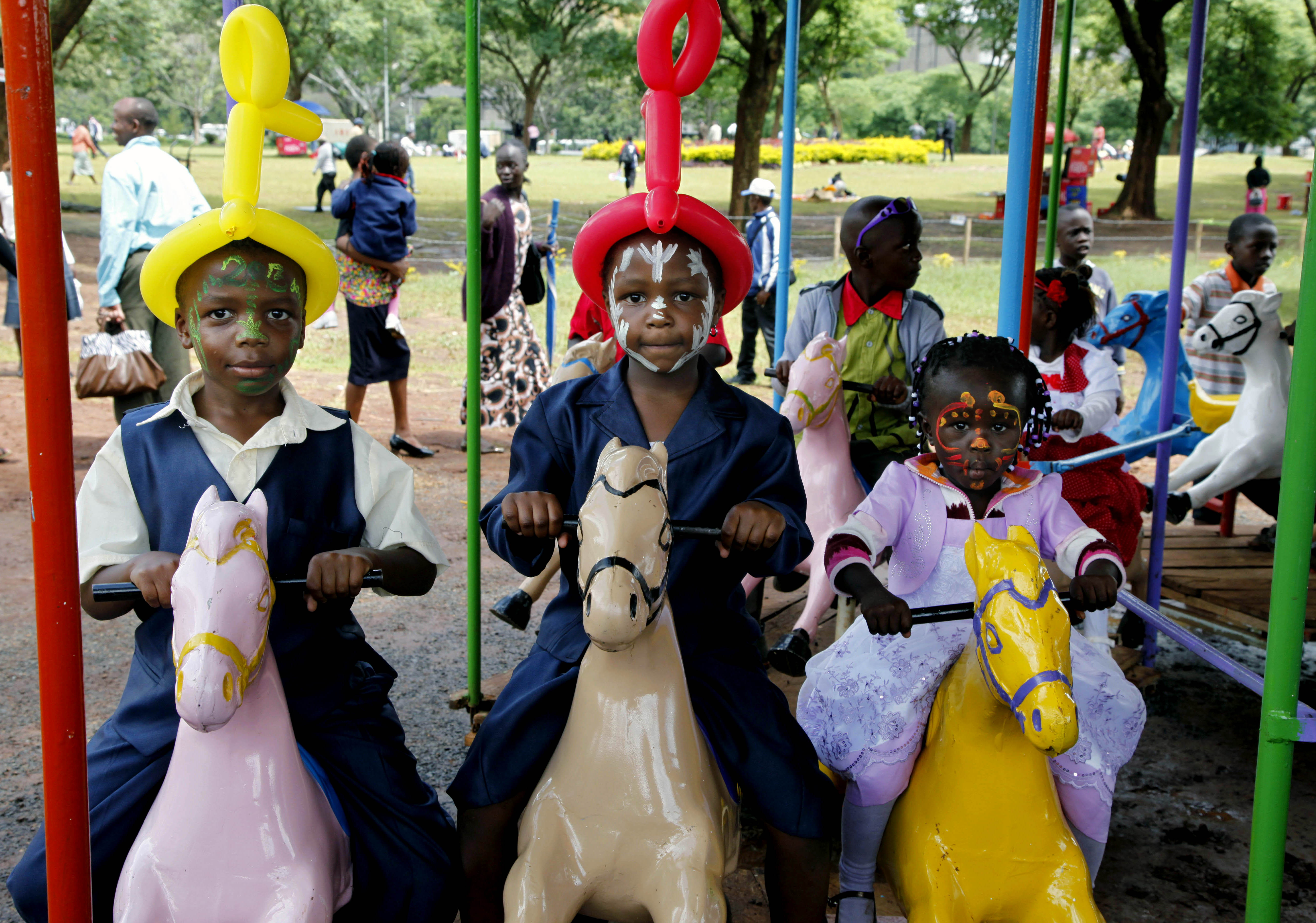 Kenyan children ride a carousel as families gather to celebrate the new year at Uhuru Park, Nairobi, Kenya.