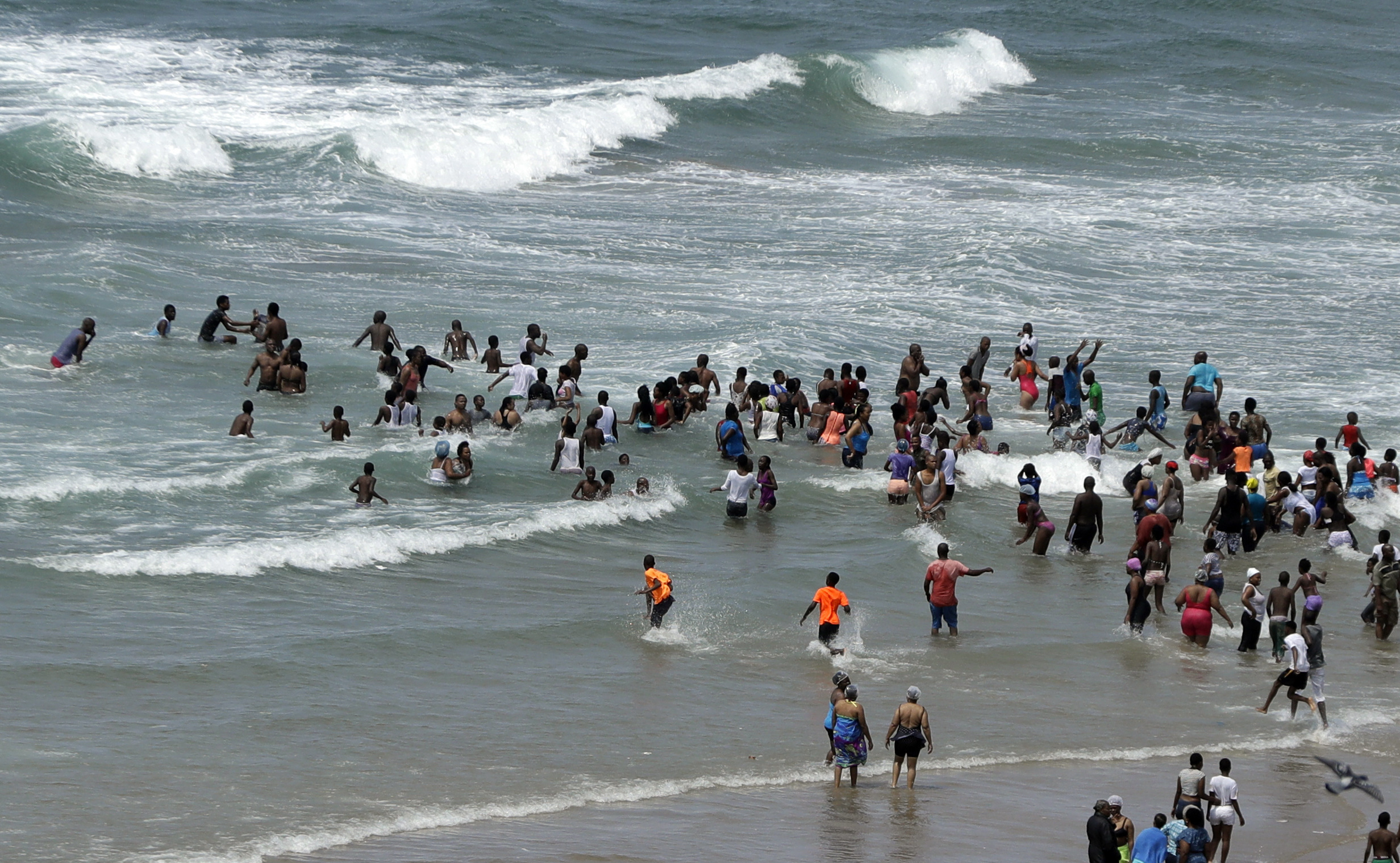 Locals and tourists swim and play on the beach in Durban, South Africa.