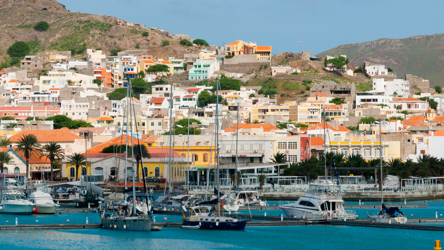 Boats float next to a small town on the coast of Cape Verde.