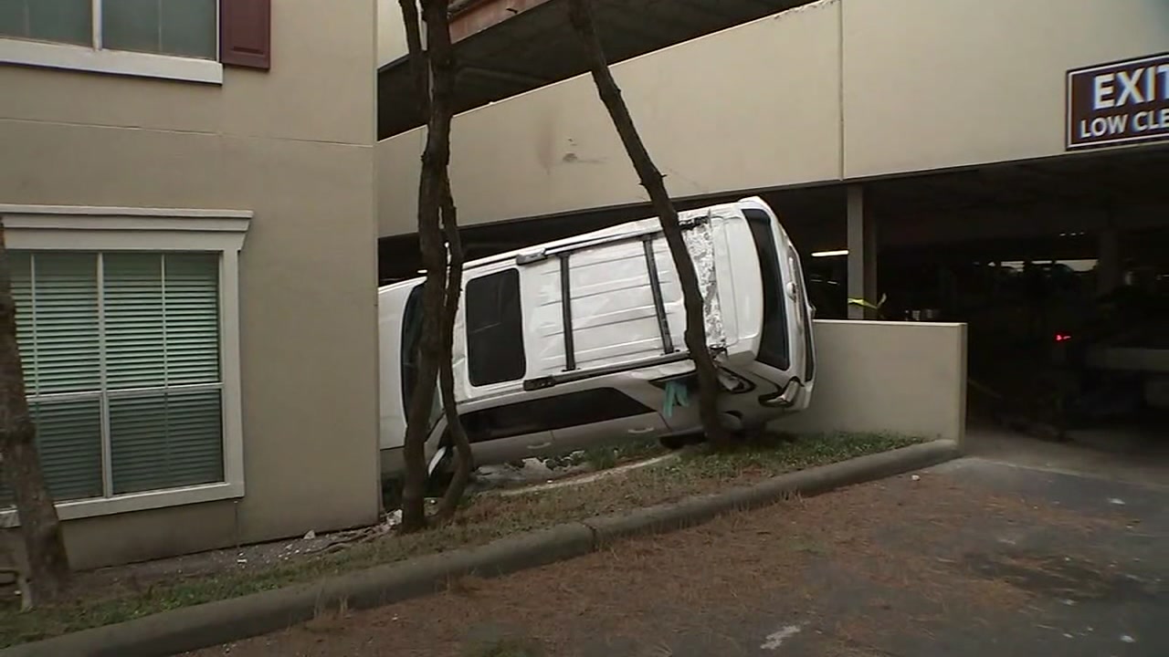 Woman pinned in vehicle after crashing through parking garage wall
