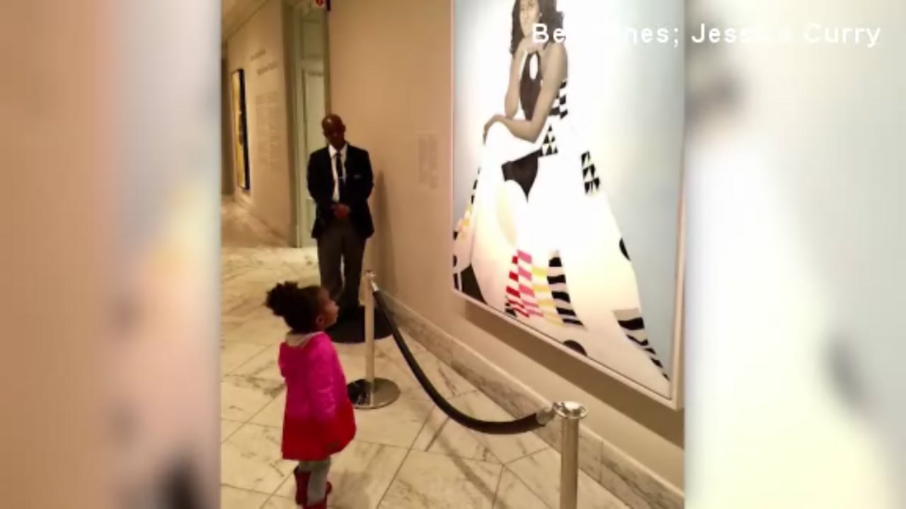 Adorable toddler enamored by portrait of Michelle Obama