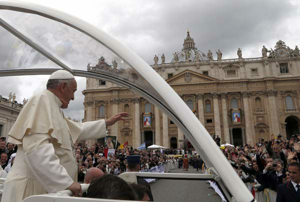 Pope Francis is driven through the crowd after presiding over a solemn ceremony in St. Peter's Square at the Vatican, Sunday, April 27, 2014. Pope Francis has declared his two predecessors John XXIII and John Paul II saints in an unprecedented canonization ceremony made even more historic by the presence of retired Pope Benedict XVI. (AP Photo/Domenico Stinellis)