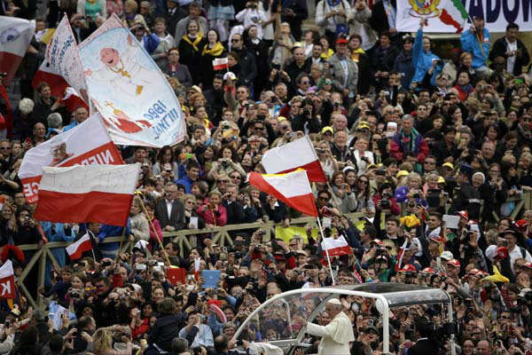 Pope Francis is driven through the crowd after presiding over a solemn ceremony in St. Peter's Square at the Vatican, Sunday, April 27, 2014. Pope Francis has declared his two predecessors John XXIII and John Paul II saints in an unprecedented canonization ceremony made even more historic by the presence of retired Pope Benedict XVI. (AP Photo/Gregorio Borgia)