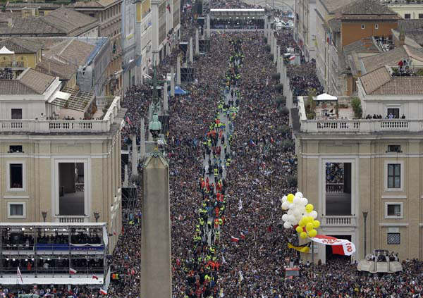 People fill via della Conciliazione, the road leading to St. Peter's Square, at the Vatican, Sunday, April 27, 2014. Pope Francis has declared his two predecessors John XXIII and John Paul II saints in an unprecedented canonization ceremony made even more historic by the presence of retired Pope Benedict XVI. (AP Photo/Andrew Medichini)
