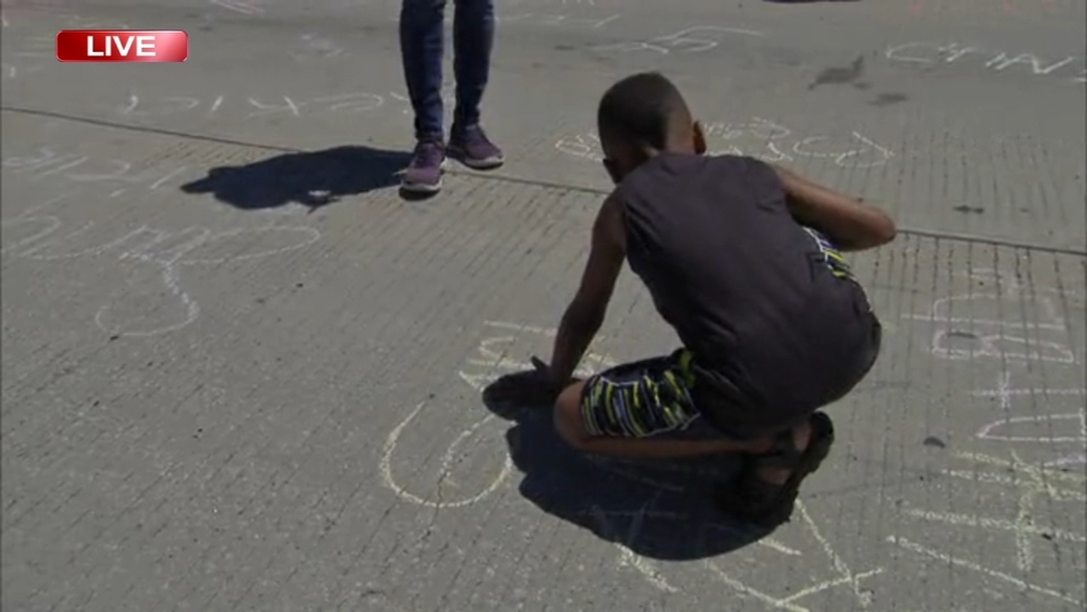 Children write in chalk during Dan Ryan peace march