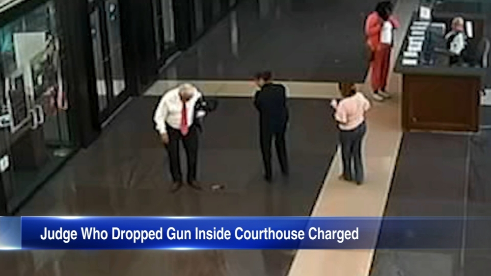 Judge charged after gun seen falling from jacket