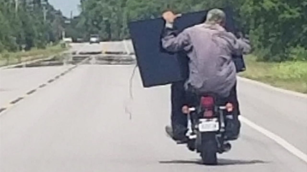 Crooks make odd getaway with stolen TV on motorcycle