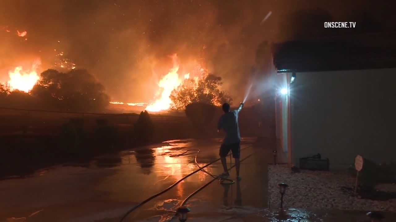 Men use garden hose to battle massive wildfire in California